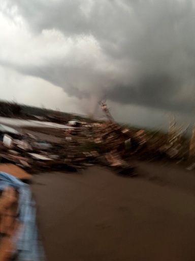Blurry photo of the April 2026 Enid tornado from the top step of a storm shelter. 